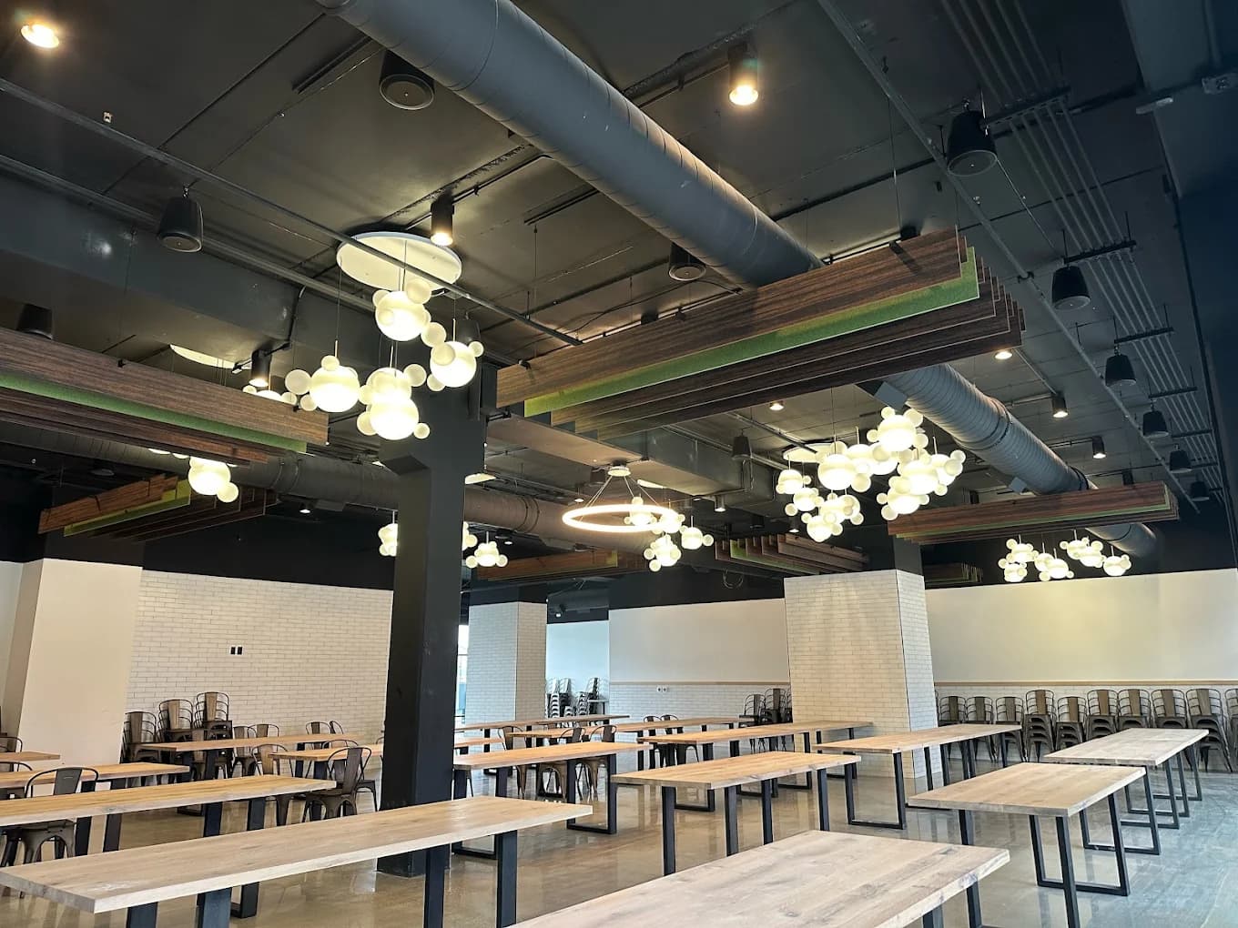 The Lights Event Center — signature globe pendant light clusters and wooden beam ceiling above the full hall