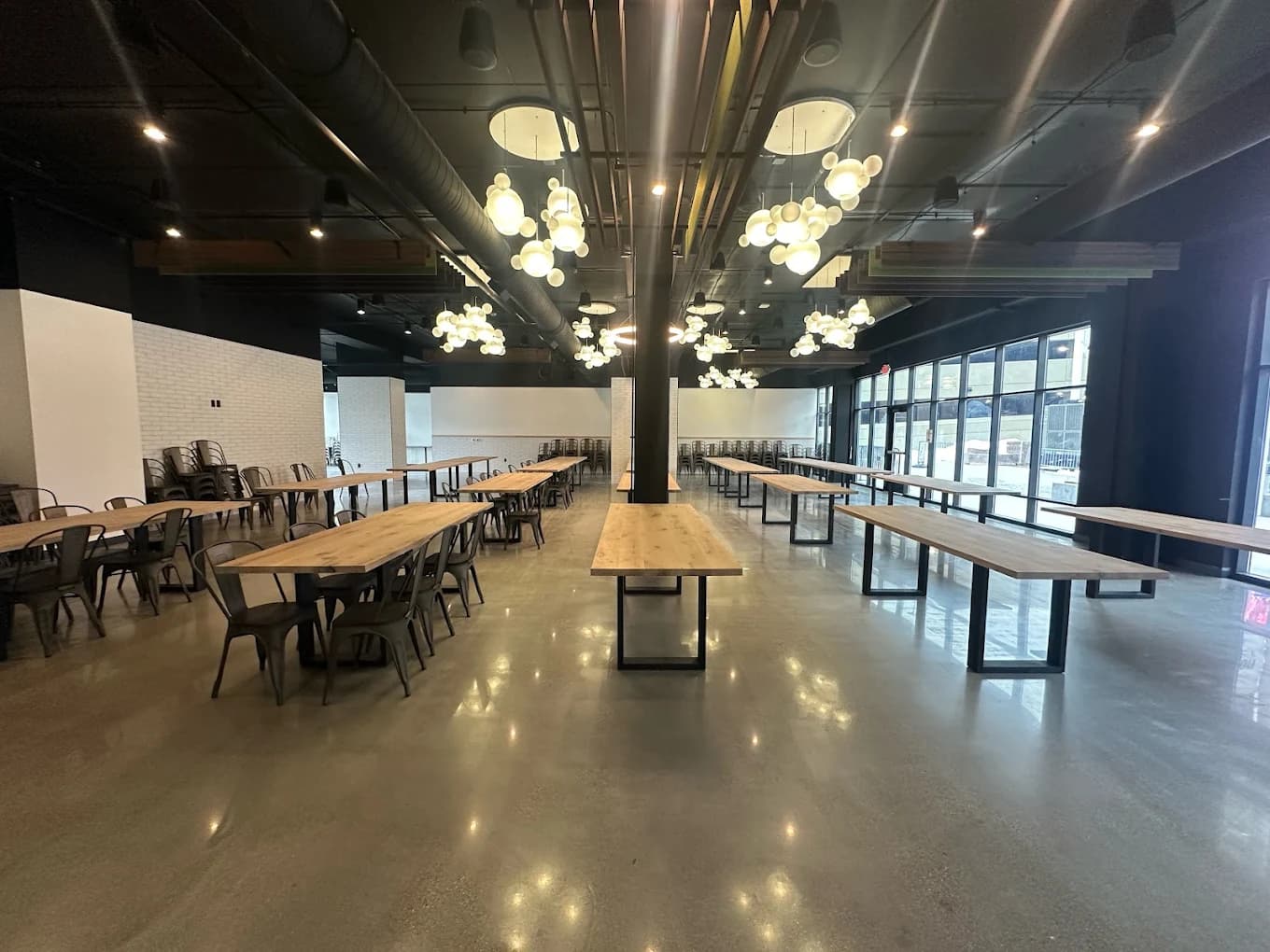 The Lights Event Center — full hall view with signature globe pendant lights, butcher block tables, and floor-to-ceiling windows